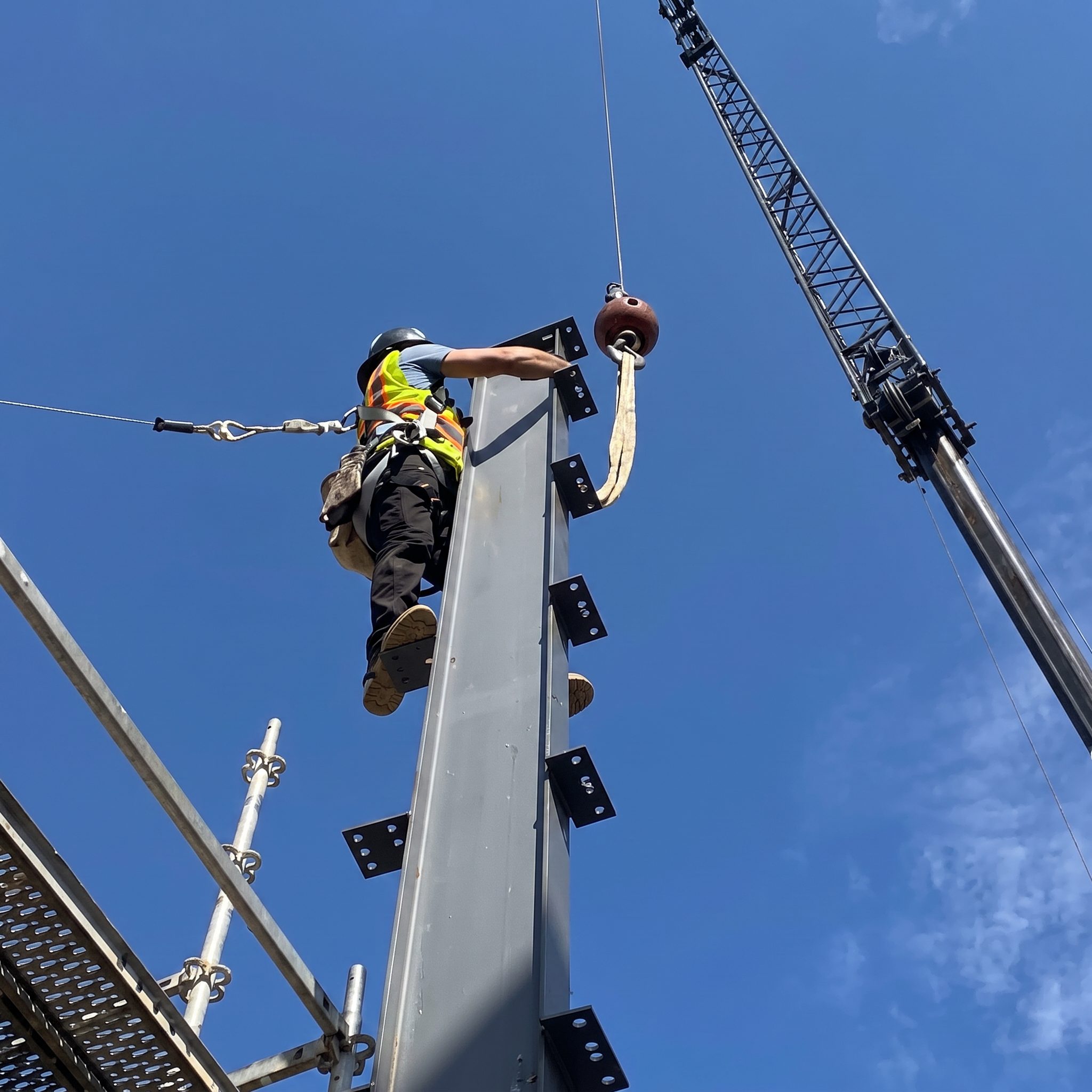 Ironworker bolting a steel column set by a crane