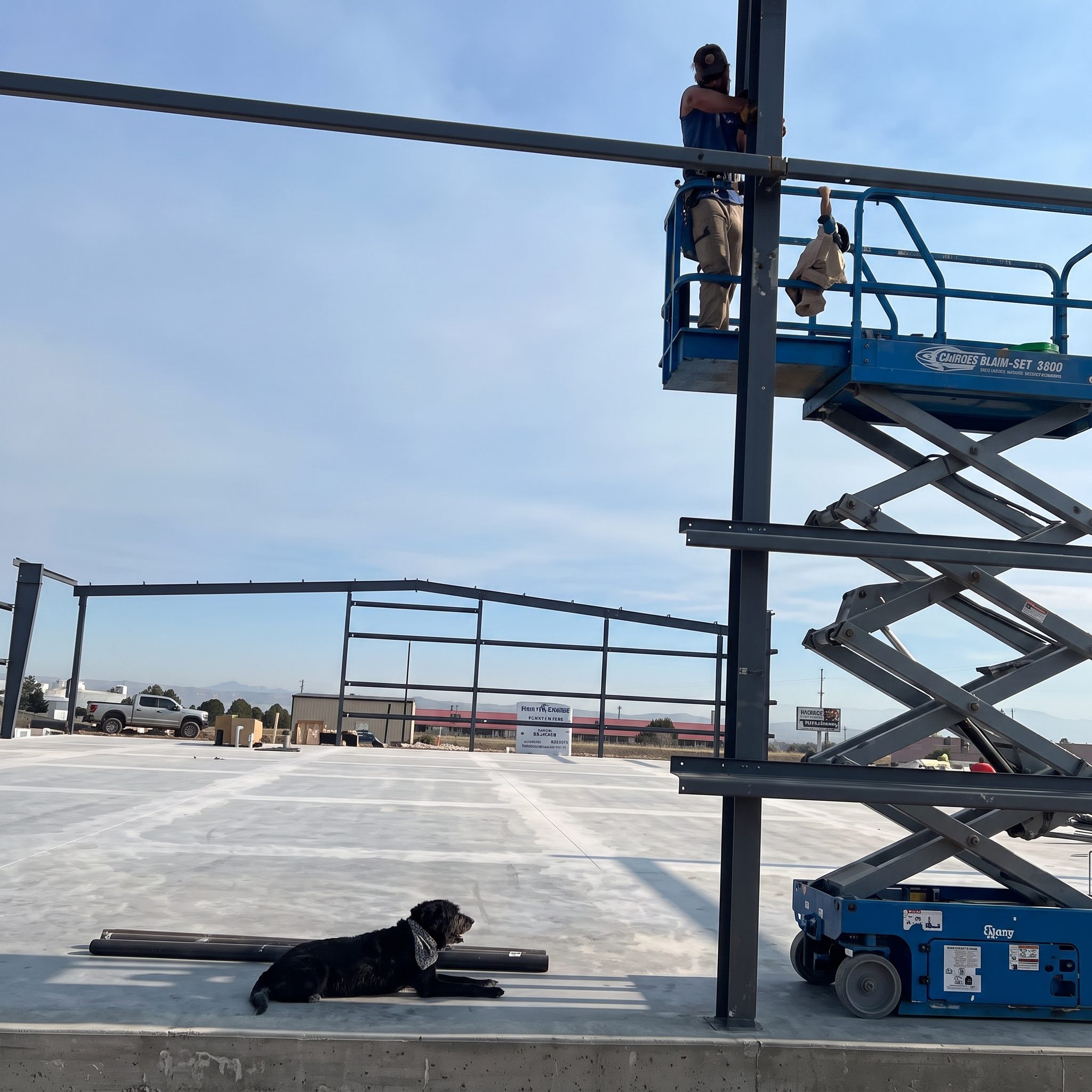 Crew installing metal fence panels from a lift